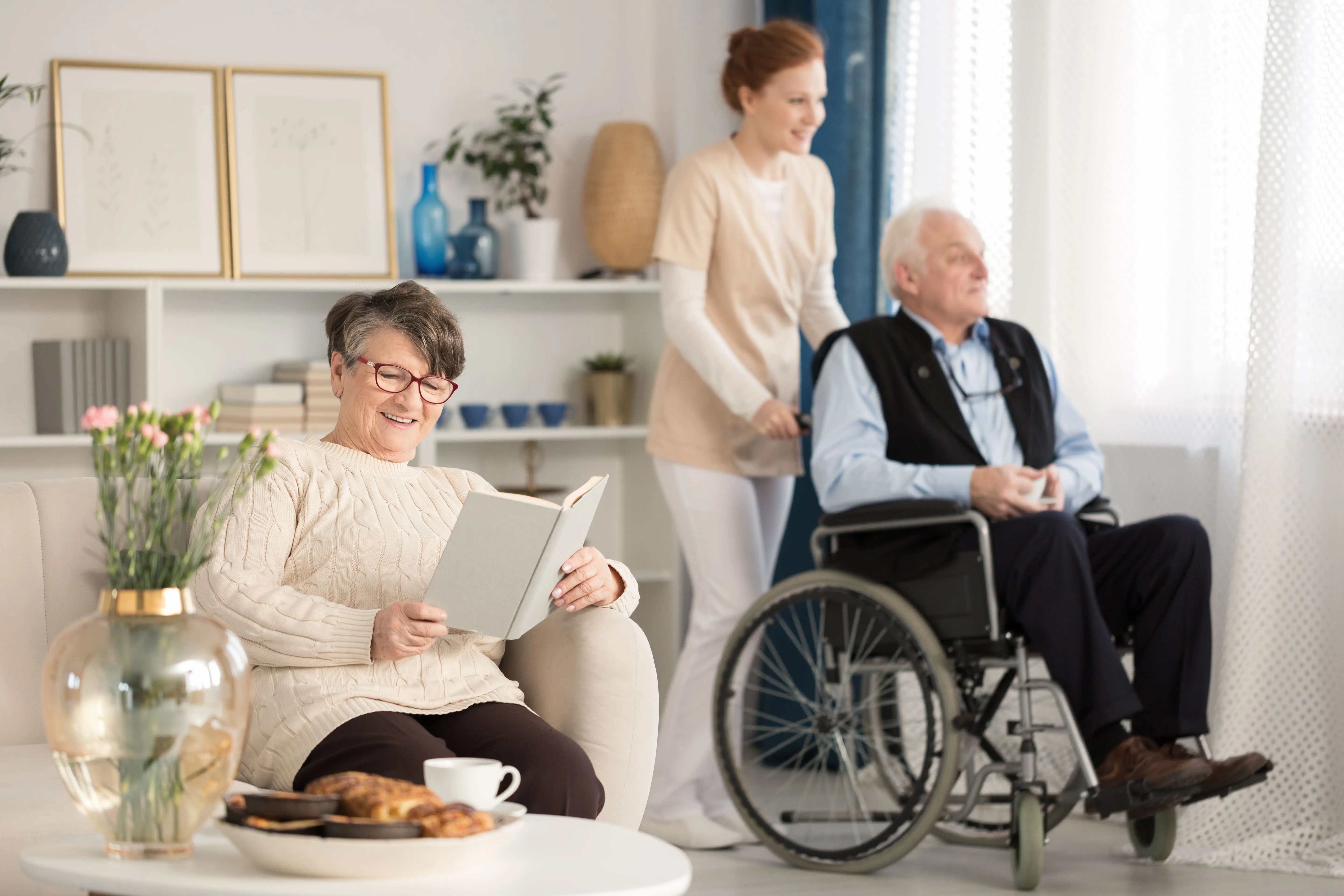 OC HomeCare caregiver providing wheelchair support while seniors enjoy a peaceful, home-like assisted living environment in Orange County