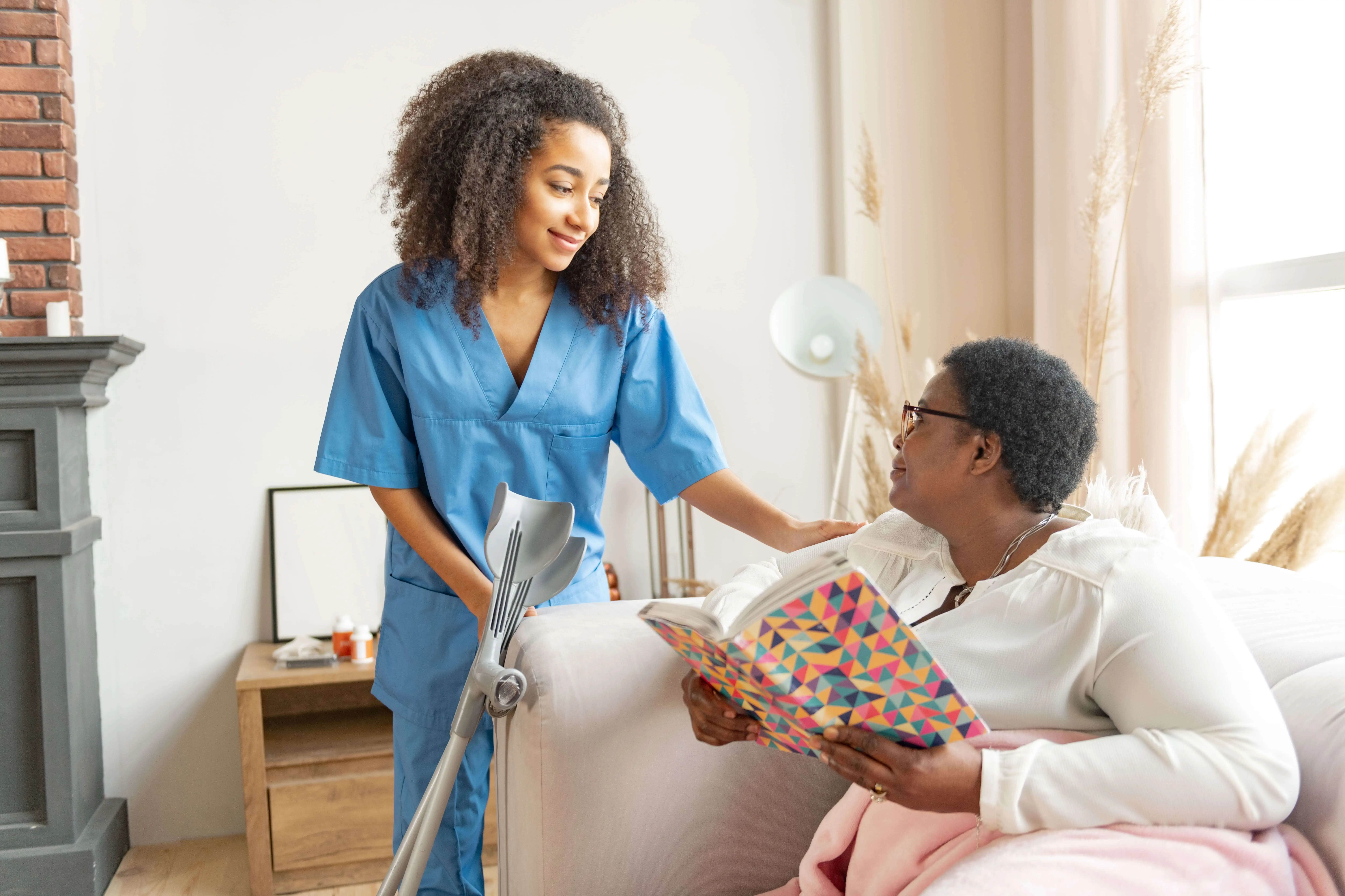 OC HomeCare caregiver assisting senior woman with mobility support and personal care in a cozy Orange County home setting