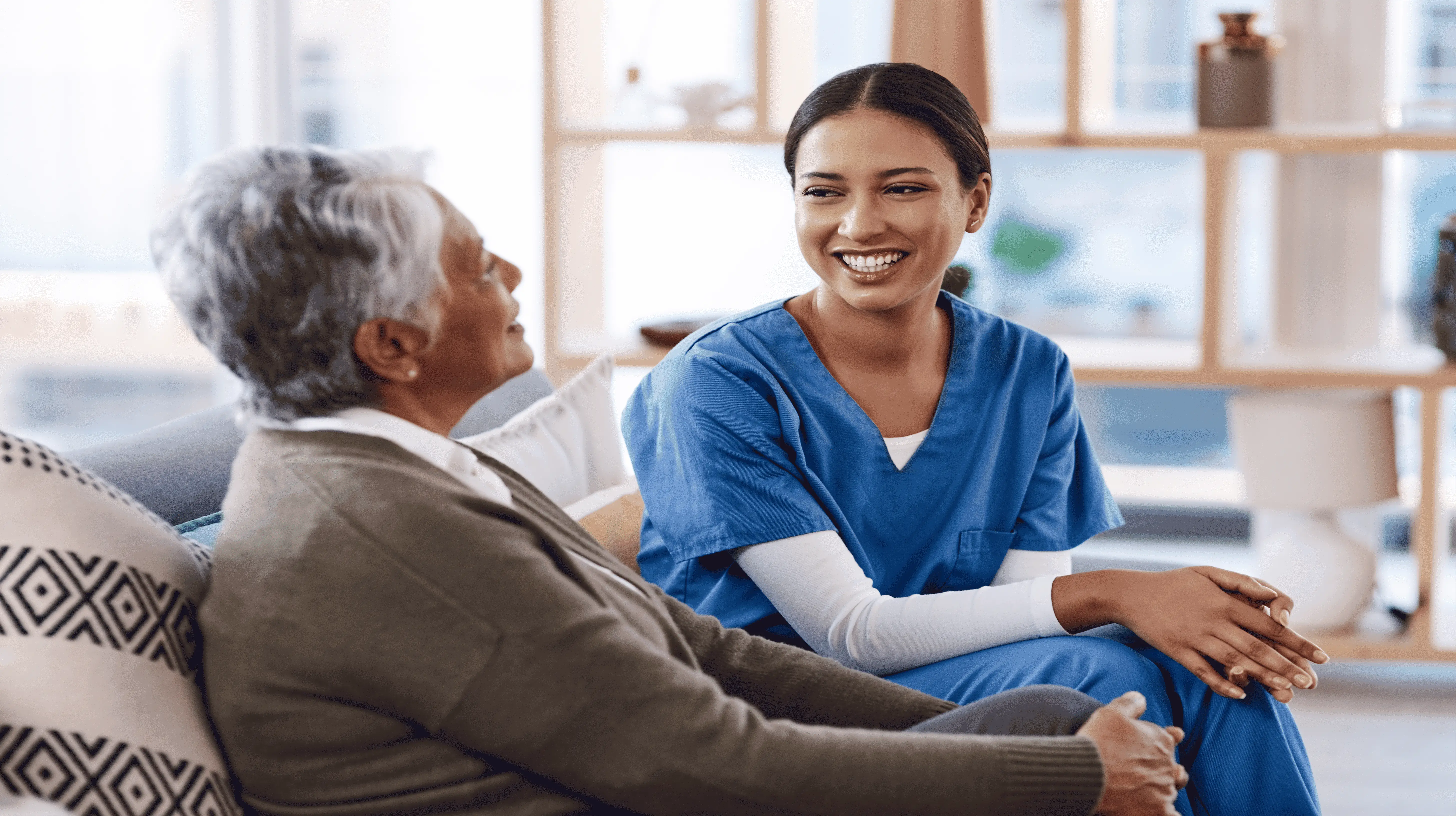 Smiling OC HomeCare caregiver offering warm, engaging companion care to a senior client in a cozy Orange County home