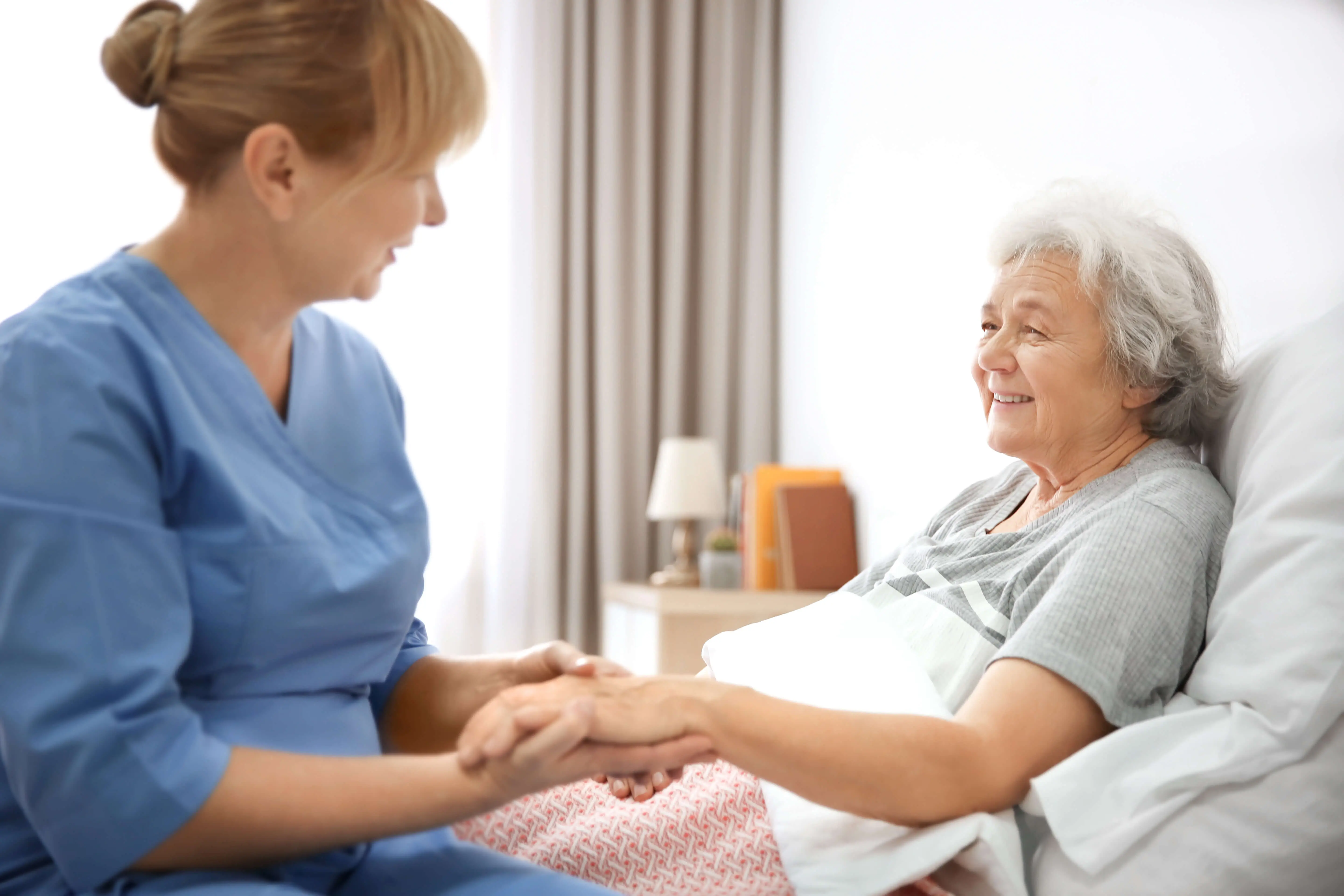 OC HomeCare caregiver delivering personalized transitional care services to a senior woman during post-hospital recovery at home in Orange County, California