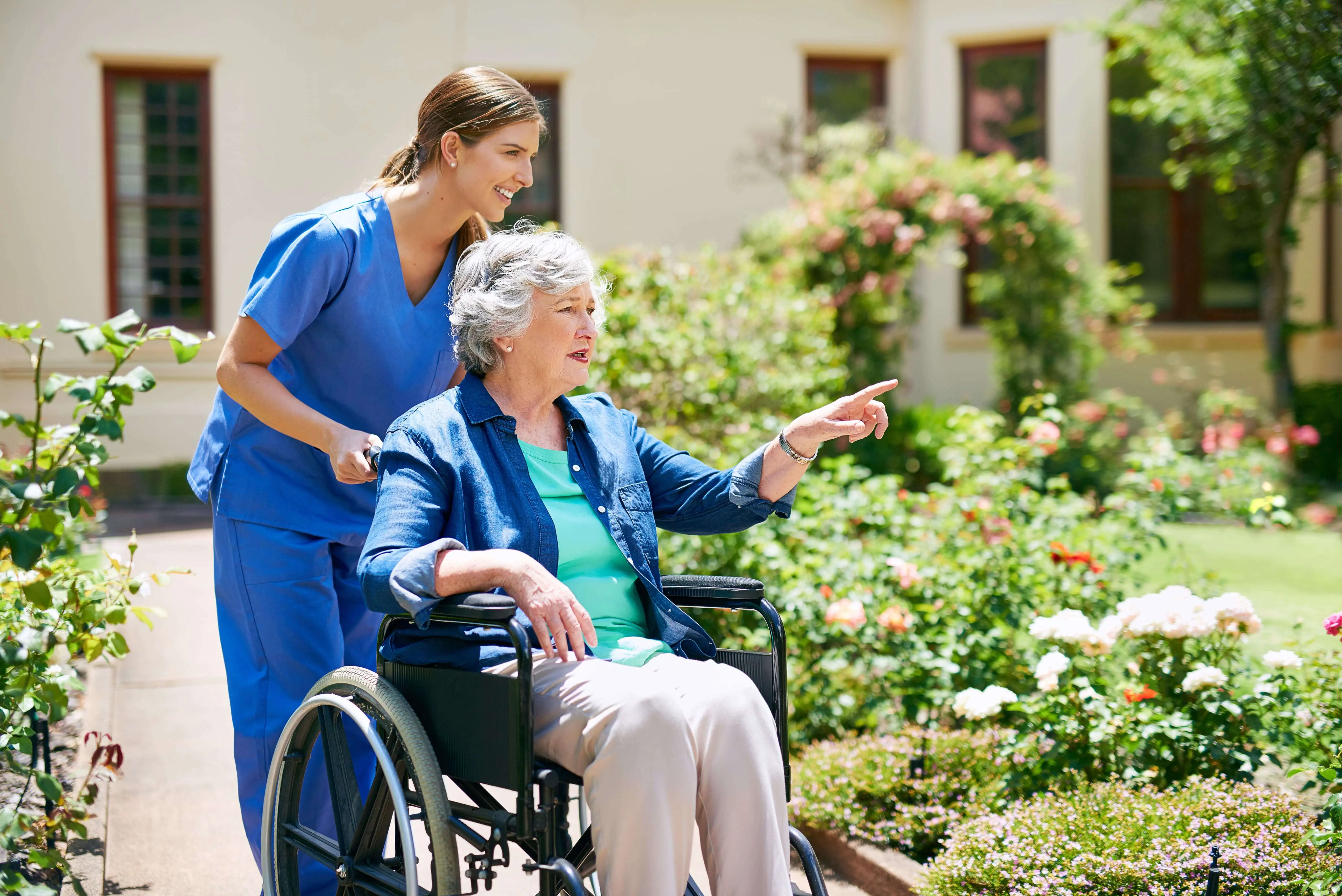 OC HomeCare caregiver assisting senior woman in a wheelchair during an outdoor walk in Orange County, CA – providing personalized mobility and companionship support