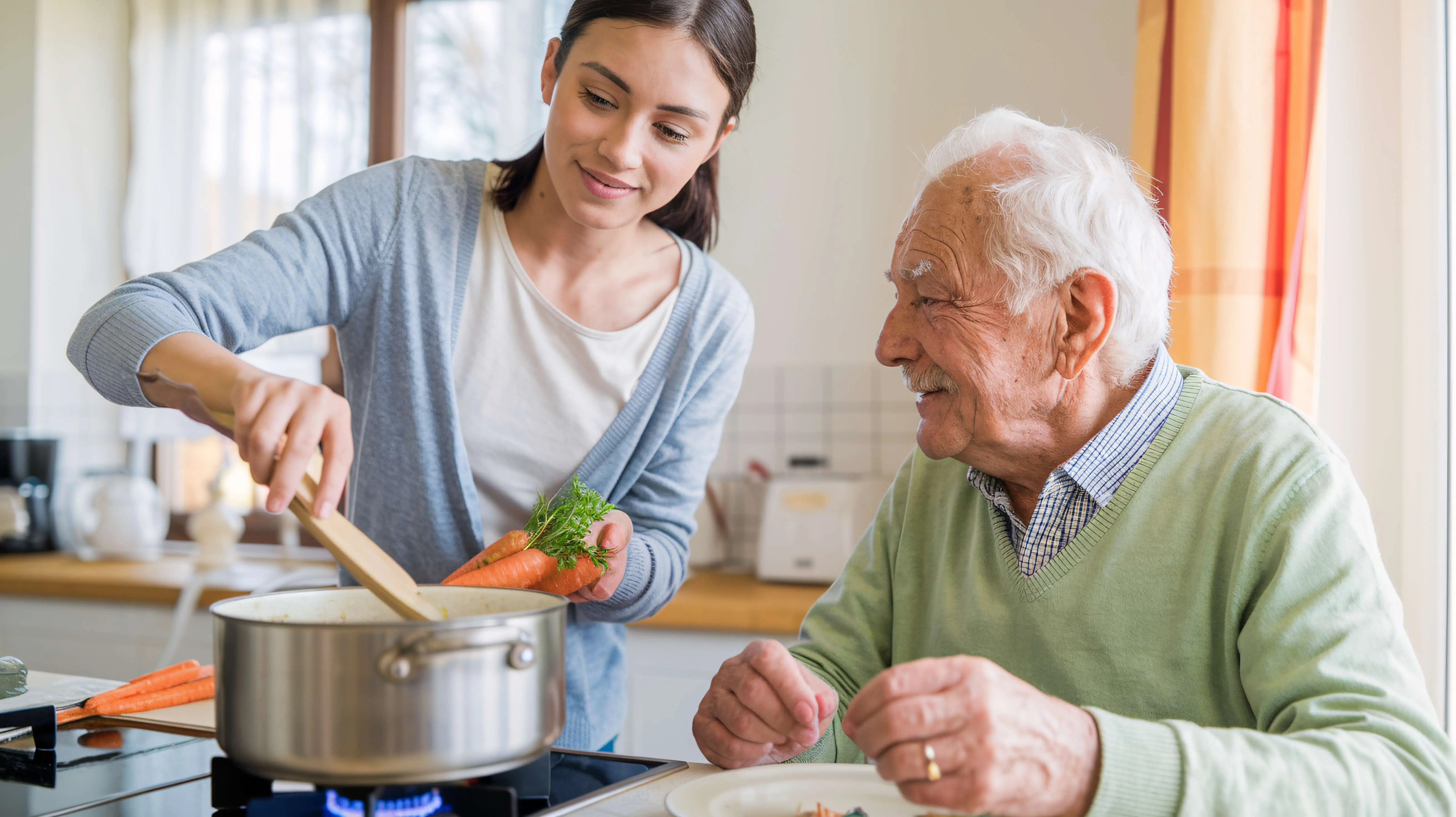 OC HomeCare caregiver preparing a nutritious home-cooked meal for senior client beginning in-home care services in Orange County